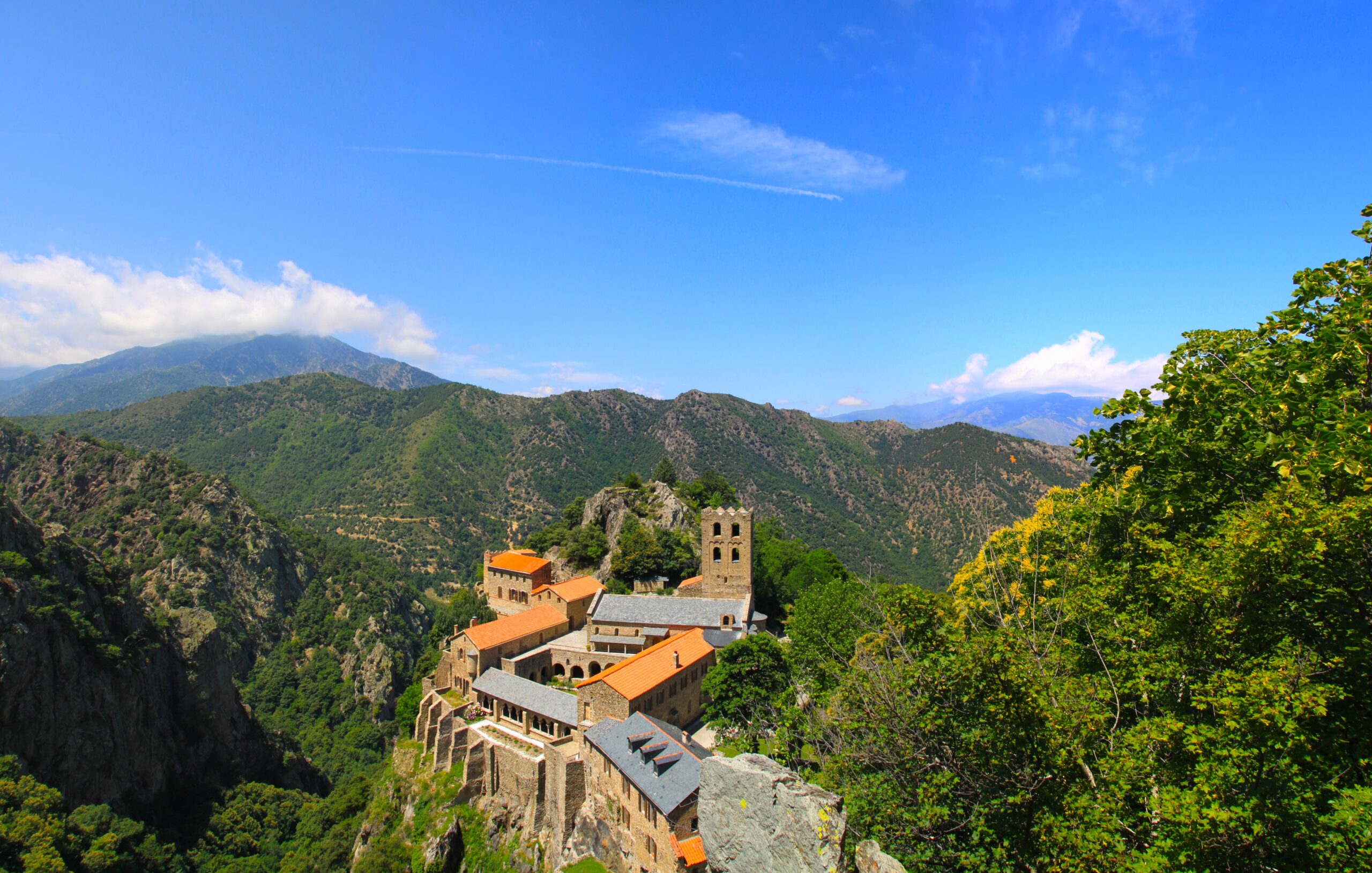 Vue d’ensemble des toitures en pierre, des arcades et du clocher de l’abbaye Saint-Martin-du-Canigou