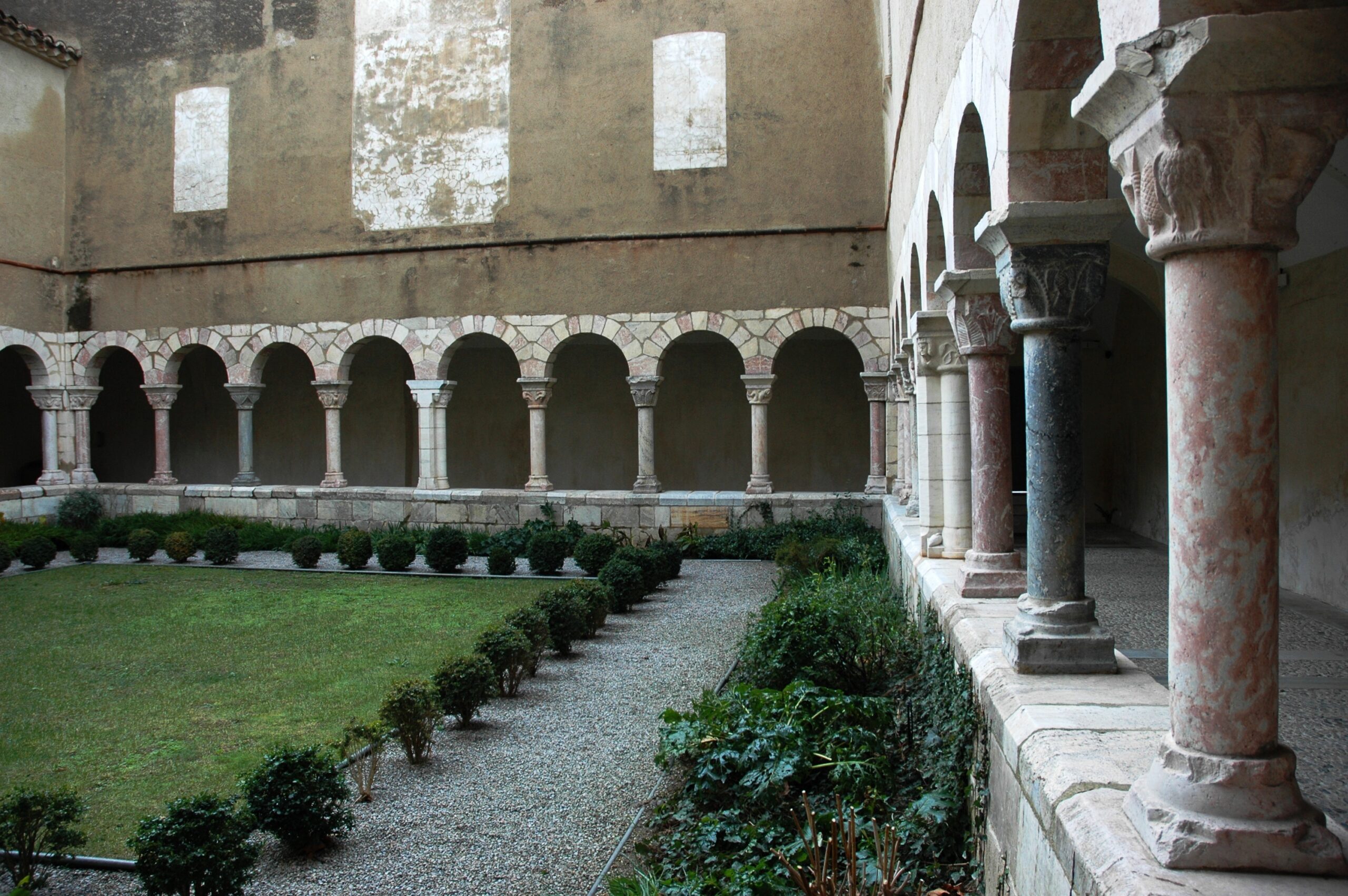 Les galeries du cloître de Saint-Génis-des-Fontaines entourant son jardin, soutenues par des colonnes de marbre polychrome