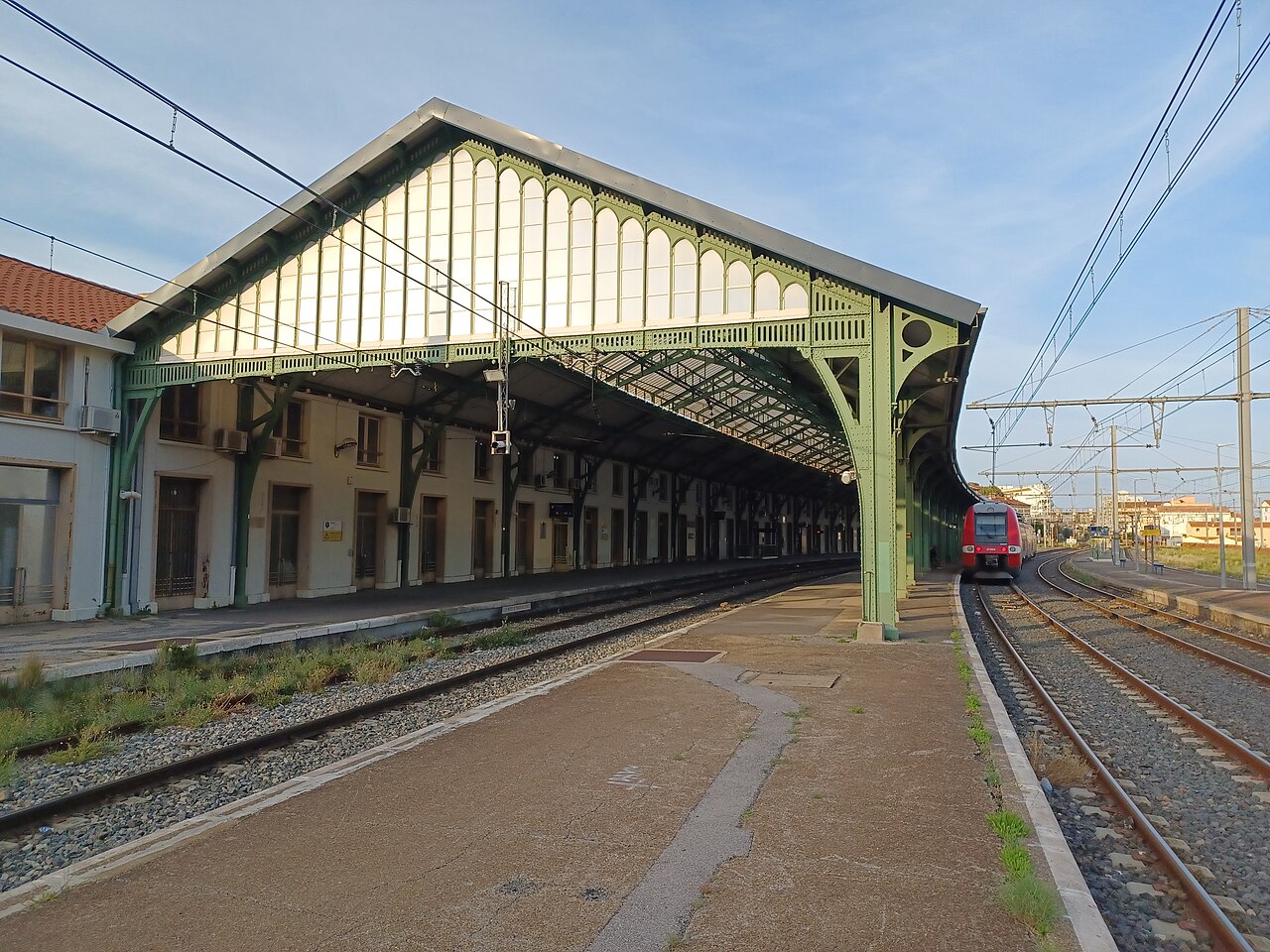 La grande verrière de la gare et les quais voyageurs en direction de la frontière.