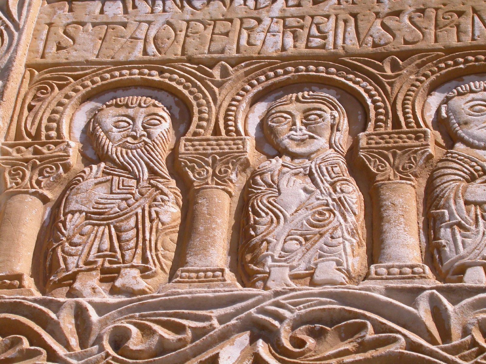 Détail photographique du bas-relief millénaire de Saint-Génis, montrant les personnages et l'inscription