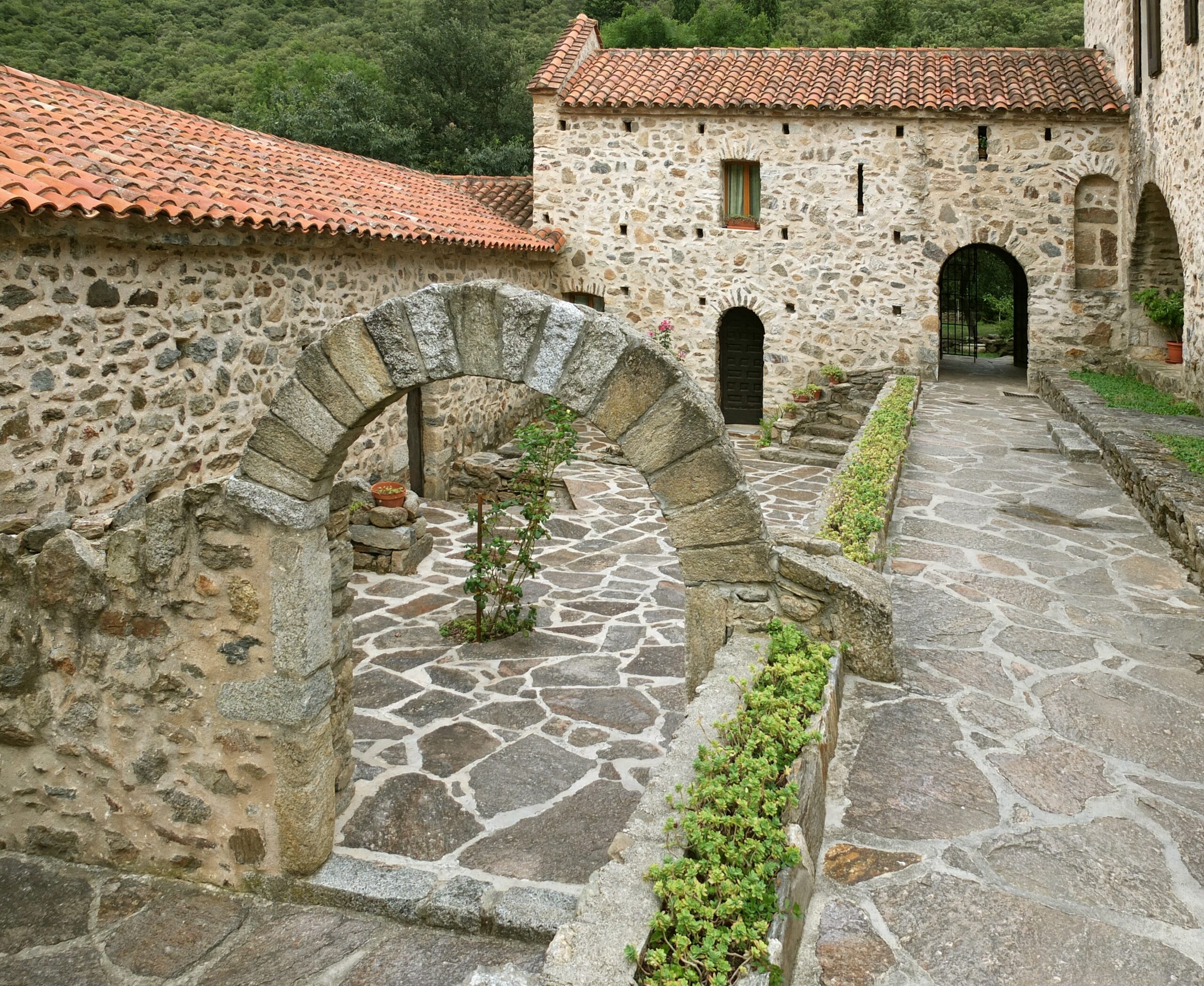 Le prieuré roman Santa Maria del Vilar, façade en pierre, clocher-mur et bâtiments conventuels à Villelongue-dels-Monts