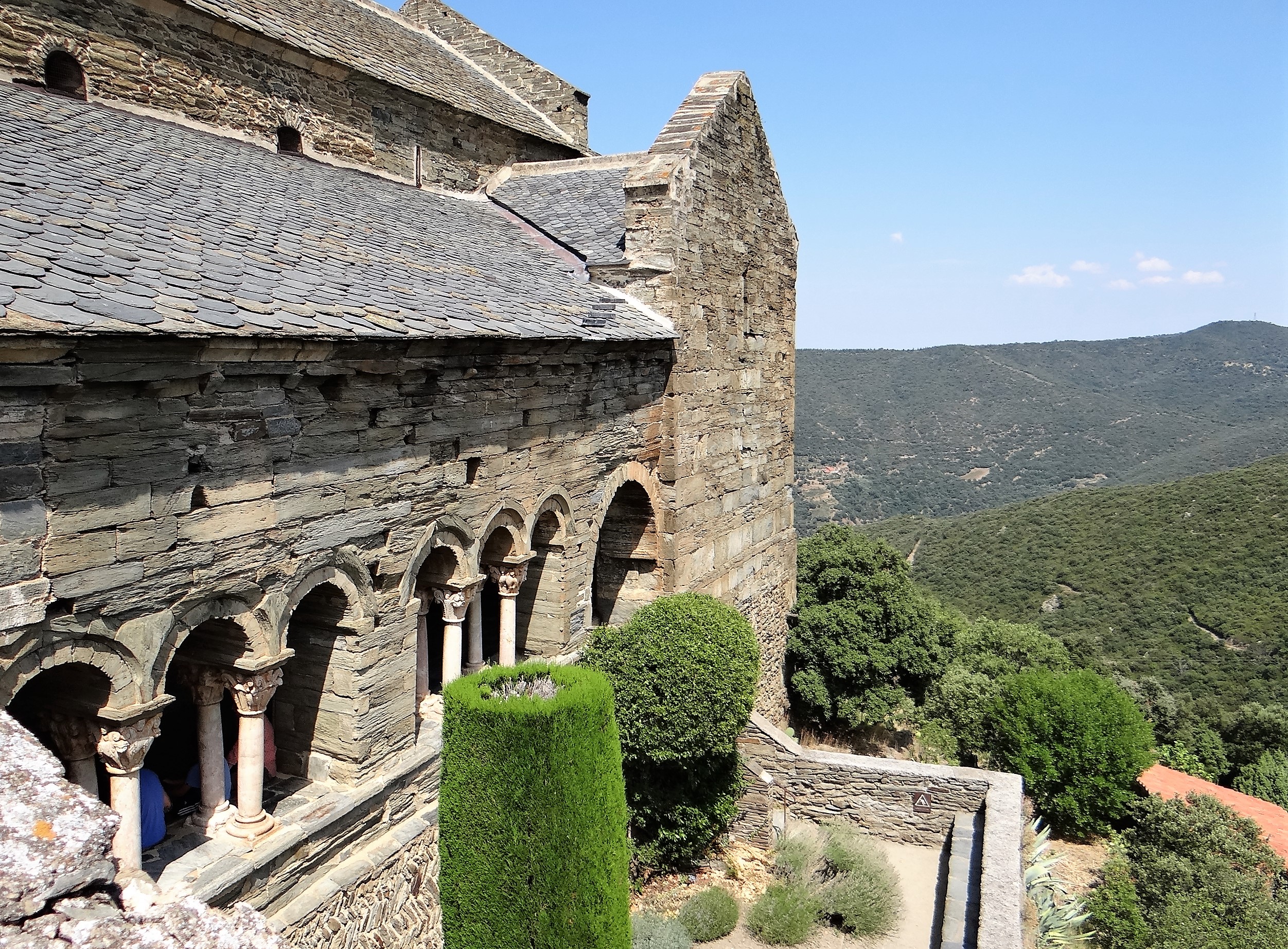 Galerie méridionale du cloître de Serrabona, colonnes romanes et vue sur les collines boisées