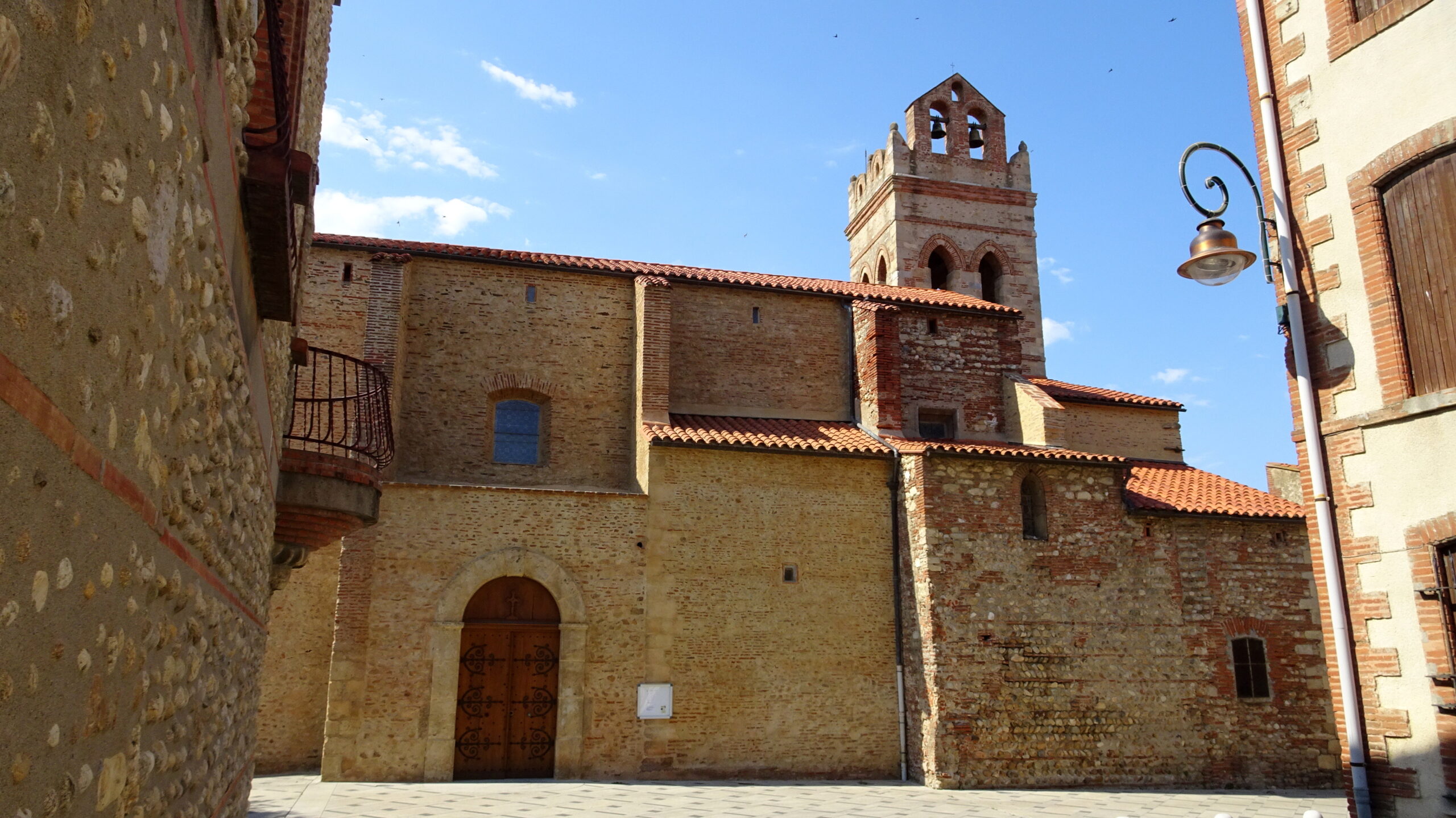 L’église Saint-Cyprien de Carthage au cœur du village, entre les façades de pierre et de brique